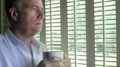 Man thinking with coffee while looking out a window Stock-Footage 11092859