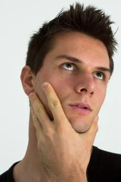 Man thinking with hand on face Foto stock
