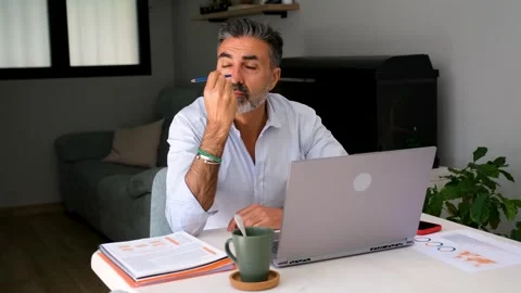 A man is thinking how to solve a problem, he is pensive in front of a laptop Vidéo 277134971