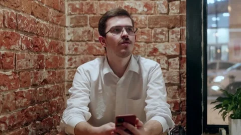 Man thinking then using phone in cafe Stock Footage 342779616