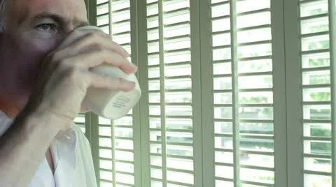 Man thinking while drinking coffee smiles at camera Stock-Footage 11092366