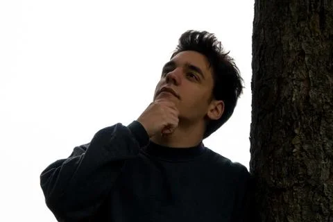 Man thinking while leaning on a tree Stock Photos