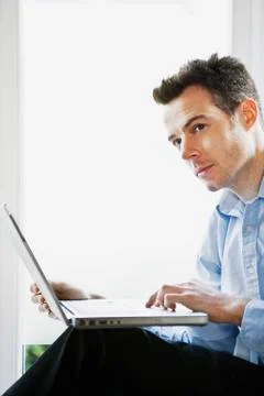A man thinking while using a laptop Stock Photos