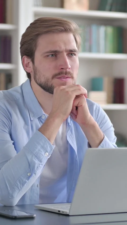 Man Thinking while Working on Laptop in Office, Vertical Video Stock Footage 339578179