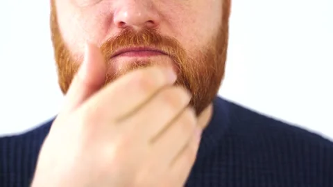 Man thinks stroking his red long beard on a white Stock Footage 234691272