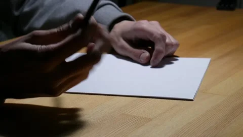 A man thinks what to write on paper Stock Footage 105360647