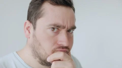 Man with thoughtful expression contemplating in a minimalistic space Stock Footage 306259599