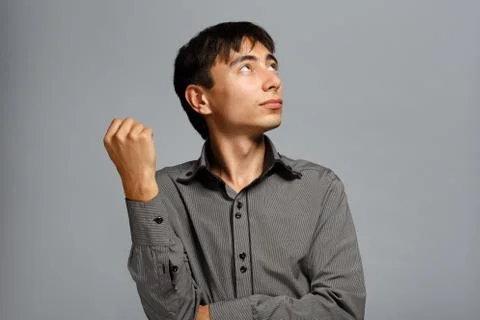 Man in thoughtful pose on grey background Stock Photos