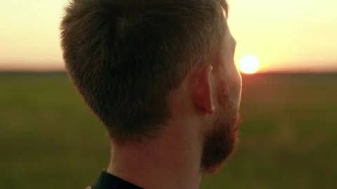 Man thoughtfully looks at sunset sky. Portrait, man face closeup, nature. Happy Stock Footage 296264605