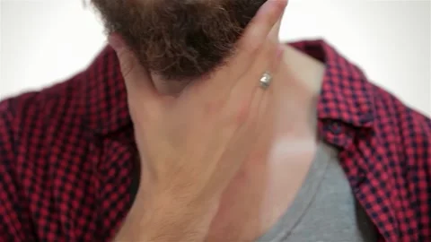 Man thoughtfully touching his stylish beard in a close-up portrait Vídeos de archivo 311659125