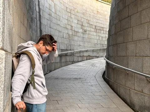 Man thoughtfully walking through a modern stone tunnel Stock Photos