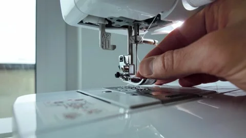 Man threading needle on sewing machine before stitching Video stock 333306995