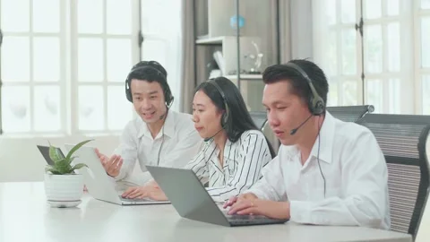 A Man Of Three Call Center Agents Wearing Headset Helping A Woman To Work Stock Footage 169518289