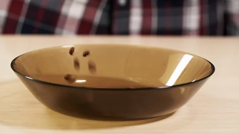 Man throw fall roasted coffee bean on plate slowmotion closeup container Arabica Stock Footage 113076903