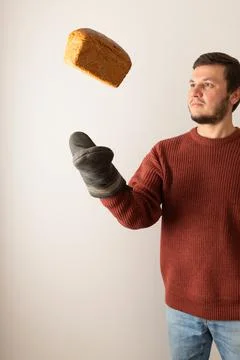 A man throw up a loaf of rye bread into the air. Stock Photos