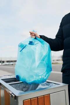 Man throwing a bag full of plastic waste to trash Stock Photos