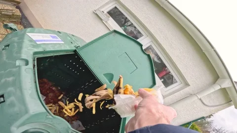 Man throwing bio waste to a compost plastic bin Stock Footage 237833024