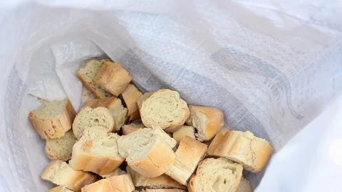 Man throwing bread on a full sack Stock Footage 83499342