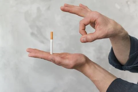 Man throwing cigarette through finger against wall Stock Photos