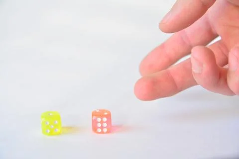 Man throwing colored dice on white background Stockfoto's