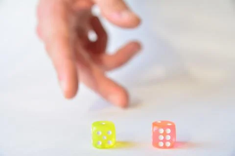 Man throwing colored dice on white background Stock Photos