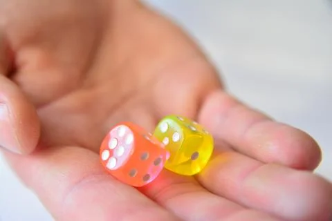 Man throwing colored dice on white background Stock Photos