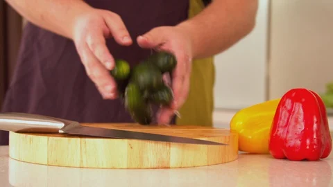Man throwing cucumbers onto wooden board Stock Footage 130056939