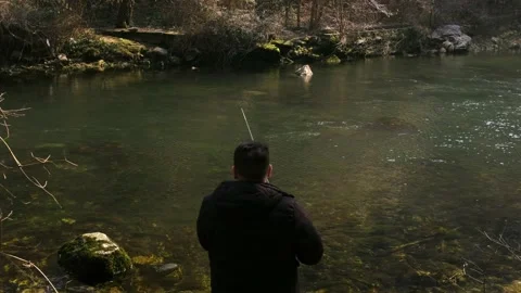 Man throwing fishhook in water. Hobby fishing on mountain lake Stock Footage 171536436