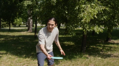 Man Throwing Frisbee Disc, Having Fun on Sunny Day in Park Stock Footage 314035013