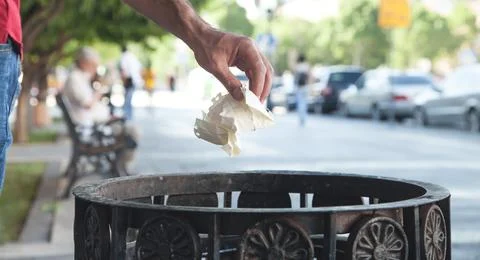 Man throwing garbage in a trash bin. Stock Photos