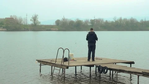 Man throwing the hook on the lake  Stock Footage 89775572