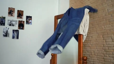Man is throwing jeans and long sleeves at the mirror Stock Footage 147900768