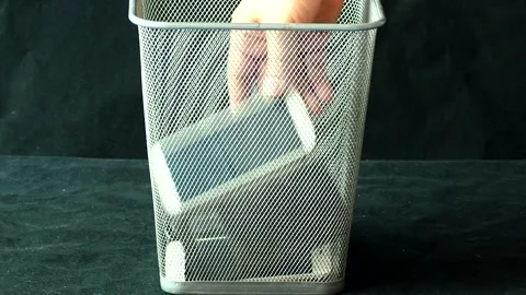 Man is throwing  mobile phone and tablet waste in to the bin, in studio  Chiangm Stock Footage 236979438