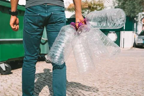 Man throwing out empty used big plastic water bottles. Bottled water pollution Stock Photos