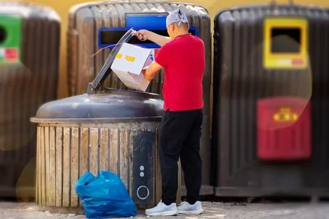 Man throwing a package in the trash can. Stock Photos