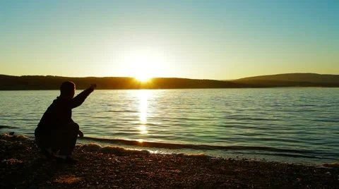 A Man Throwing Pebbles Into Water Video stock 51843917