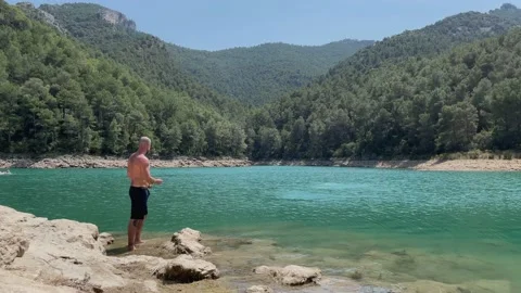Man throwing pebbles in water Stock Footage 158717374