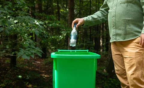Man throwing plastic bottle into trash bin. Stock Photos