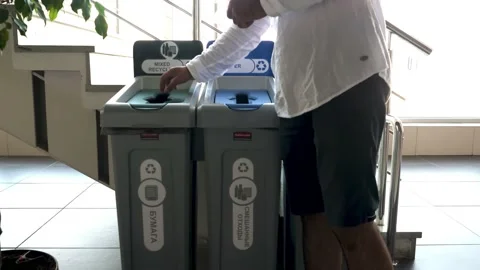A man throwing plastic container in a public recycle bin. HDR. Waste segregation Stock Footage 157809592