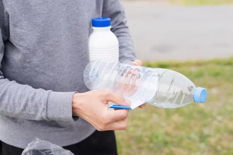 Man throwing plastic containers at plastic recycling point. Stock Photos