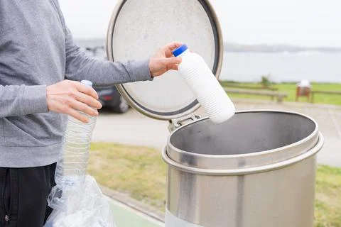 Man throwing plastic containers at plastic recycling point. Stock Photos