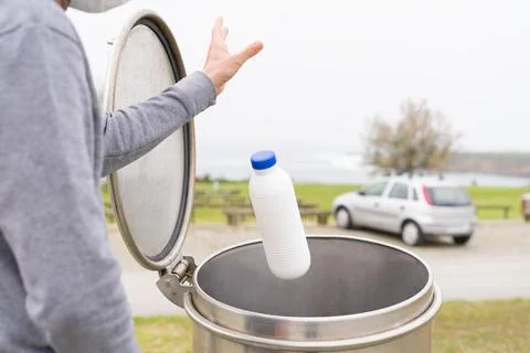 Man throwing plastic containers at recycling point. Social responsibility. Stock Photos