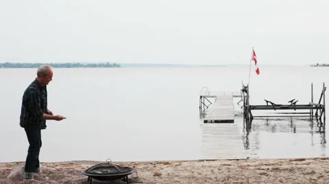 Man Throwing Skipping Stone at Lake Stock Footage 50989627