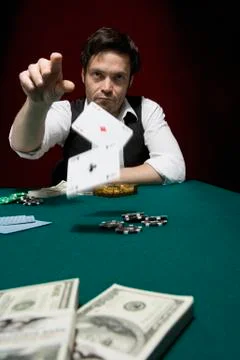 A man throwing two ace cards at a high stakes poker game Stock Photos