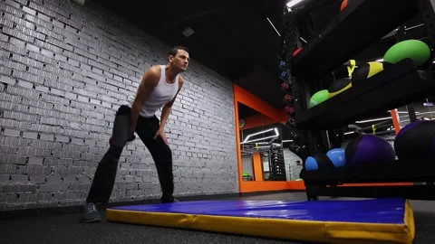 Man throws and catch kettlebell in gym of fitness club. Slow motion Stock Footage 276367512