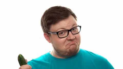Man throws up and eats cucumber at studio with white background Stock Footage 112769511
