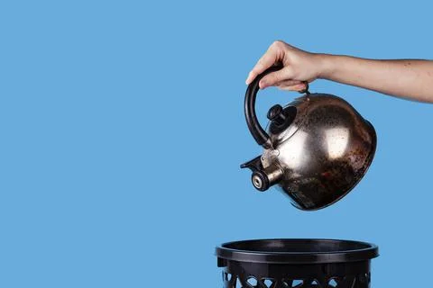 The man throws away the old kettle. Stock Photos