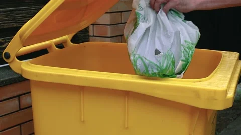 A man throws a bag of trash into a waste container. Stock Footage 159121680