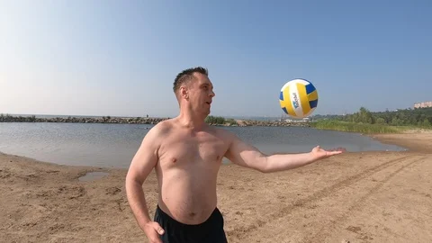Man throws the ball with his hands on the beach Stock Footage 114422866