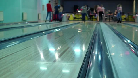 A man throws a bowling ball down the lane at you and the ball rolls by Stock Footage 147623713
